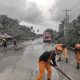 Firemen sweeping volcanic ash on road
