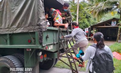 Soldiers helping individuals to get in their truck
