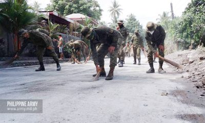 Military men sweeping roads