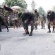 Military men sweeping roads