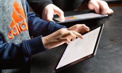 Middle school students complete classwork on tablet computers.