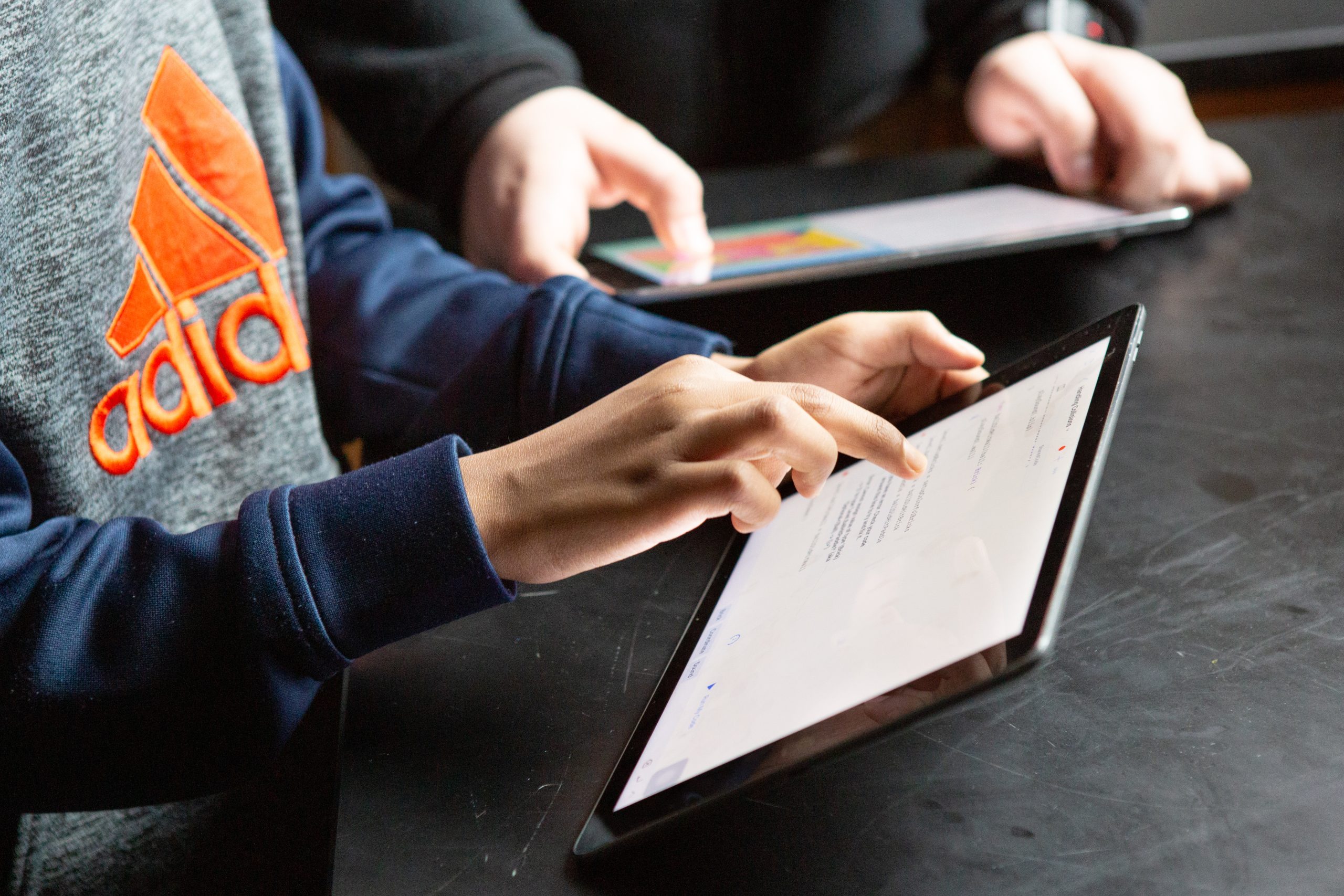 Middle school students complete classwork on tablet computers.