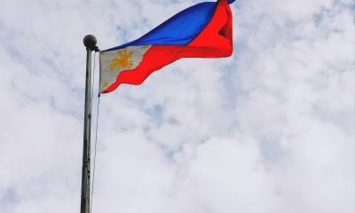 Philippine Flag Swaying by the Wind Under White Sky