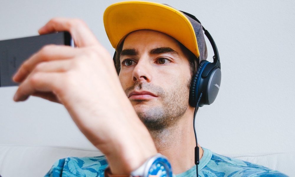 man wearing headphones and holding a phone