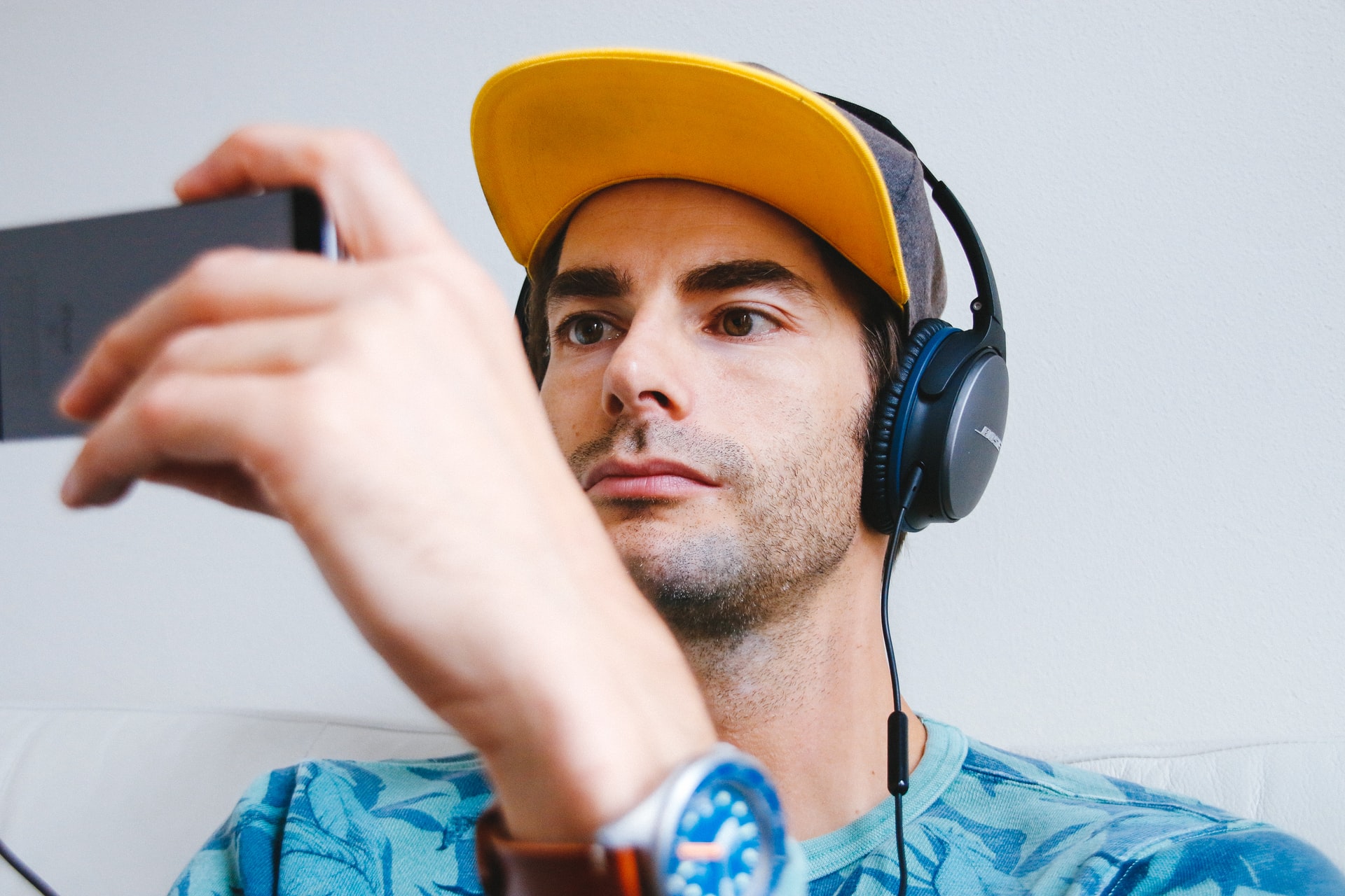 man wearing headphones and holding a phone