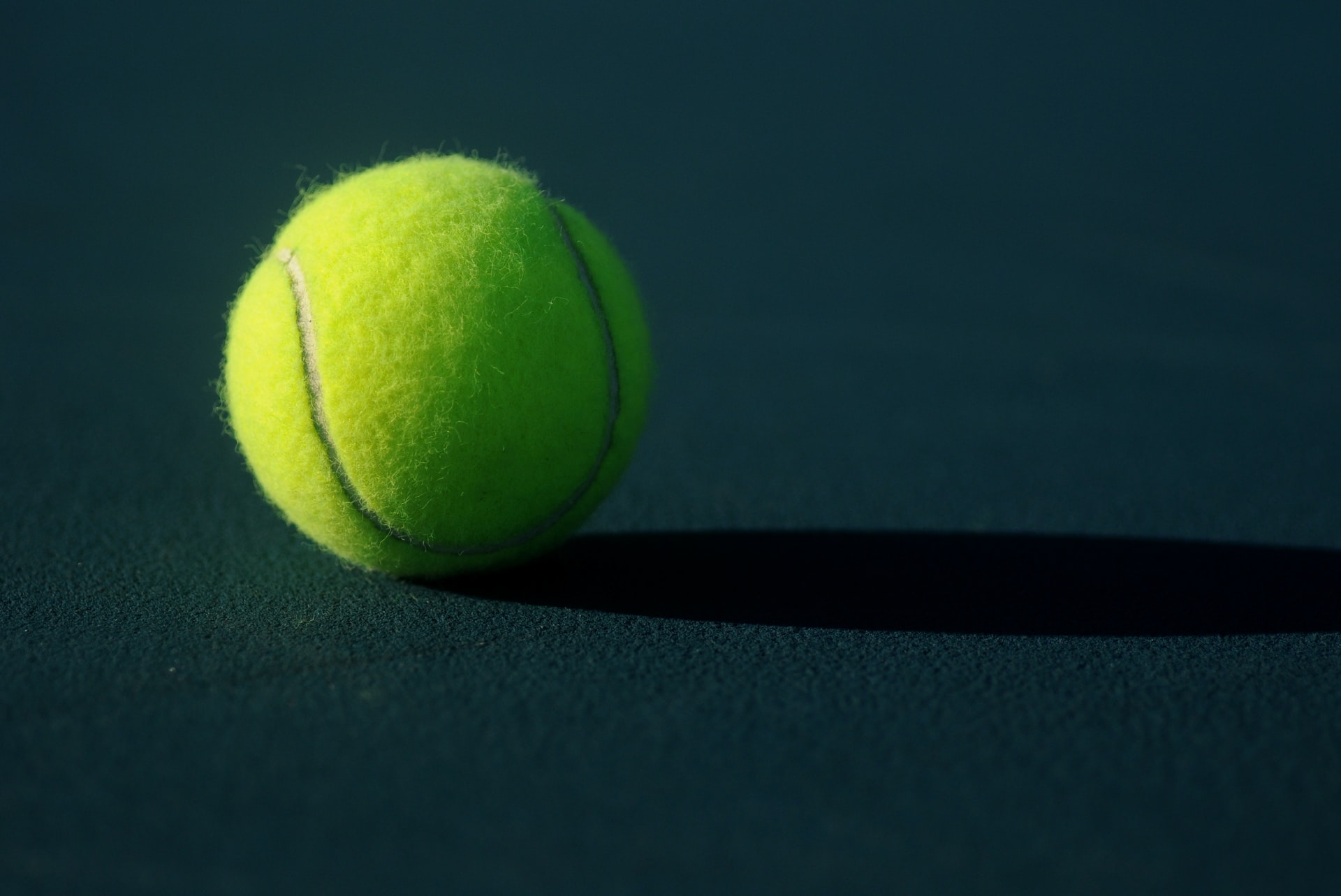 Tennis ball on dark green surface