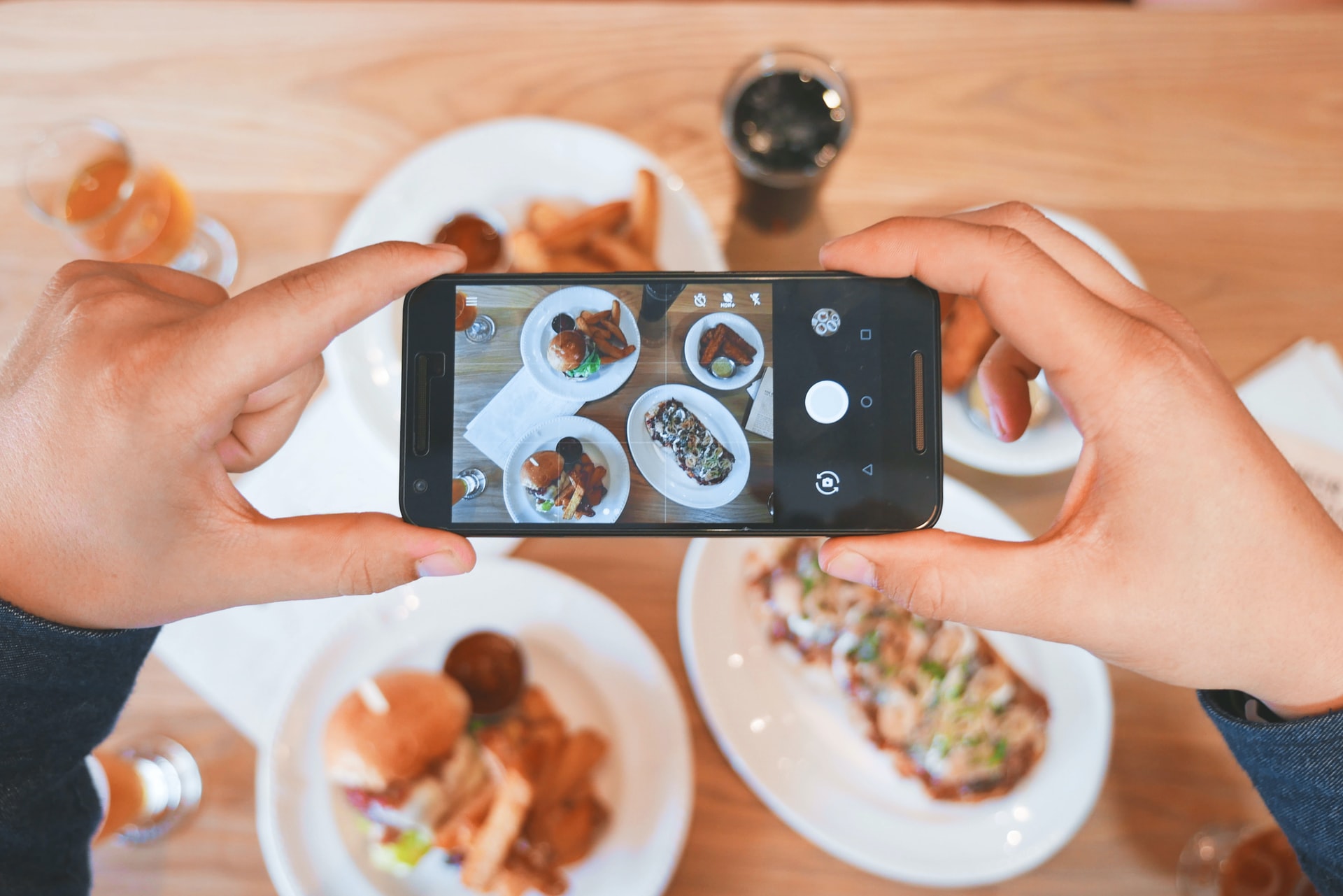 Phone taking a photo of food on table