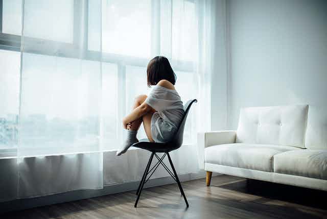Girl sitting on a chair facing the window