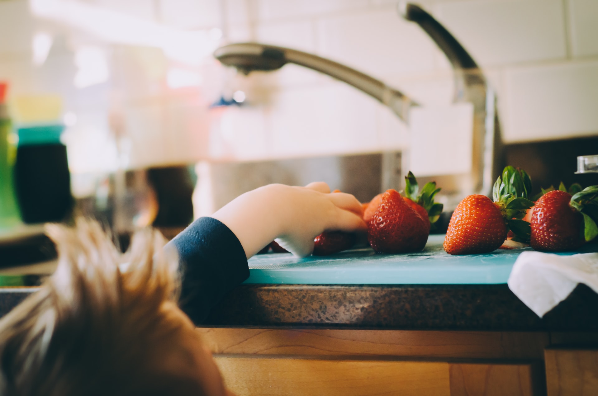 kid trying to reach a strawberry