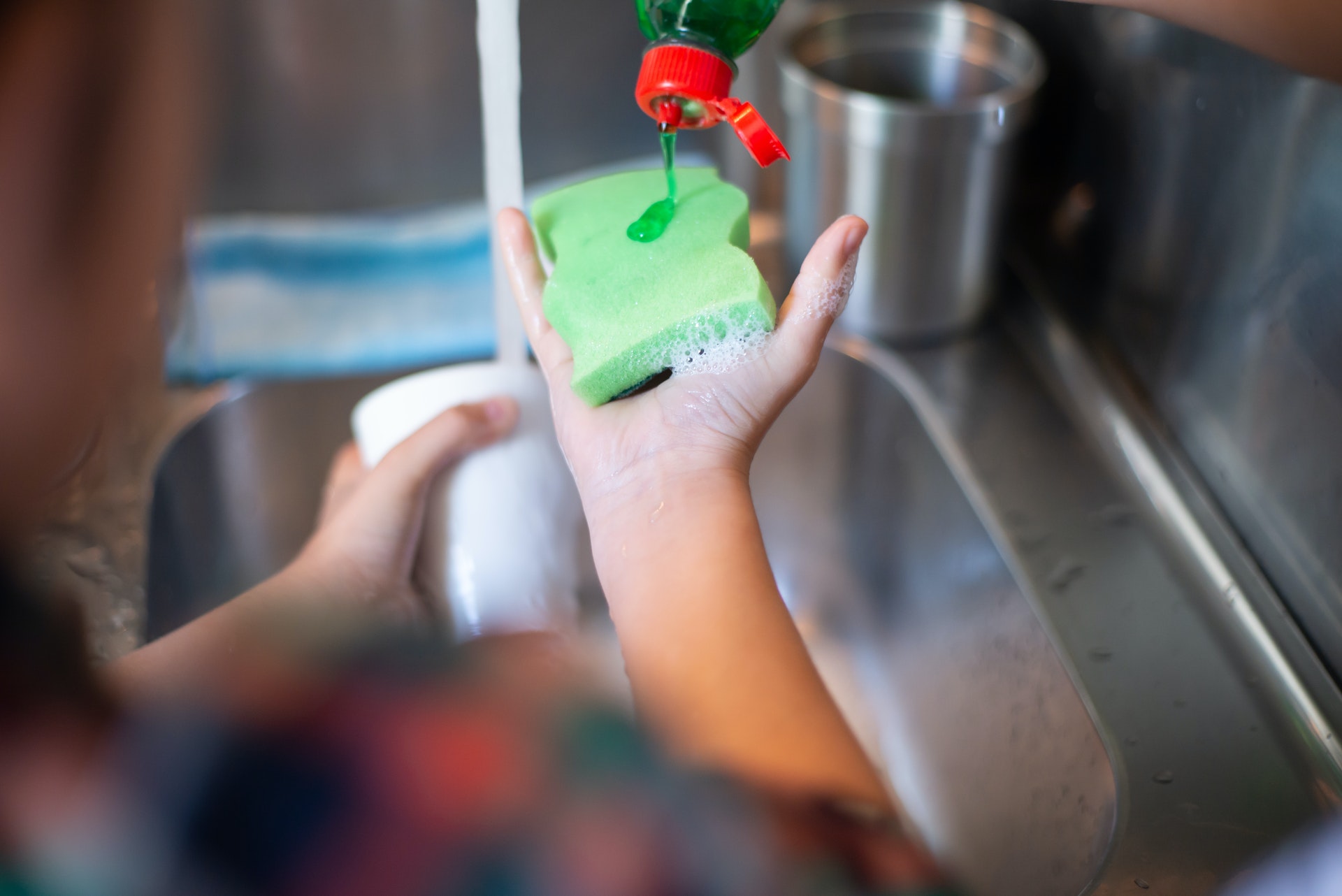 Dishwashing liquid on sponge in a hand