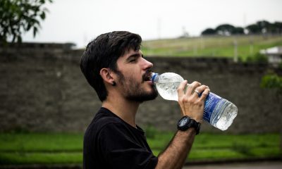 man drinking from plastic bottle