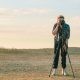 guy taking picture in an open field