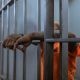 tattooed man wearing orange shirt inside a jail