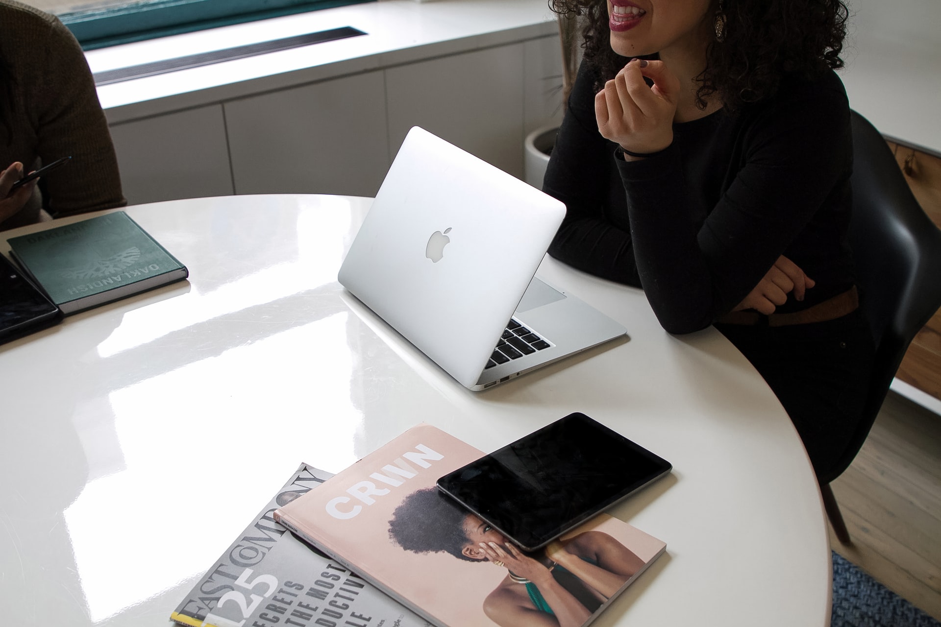 Meeting on table with laptop and magazines