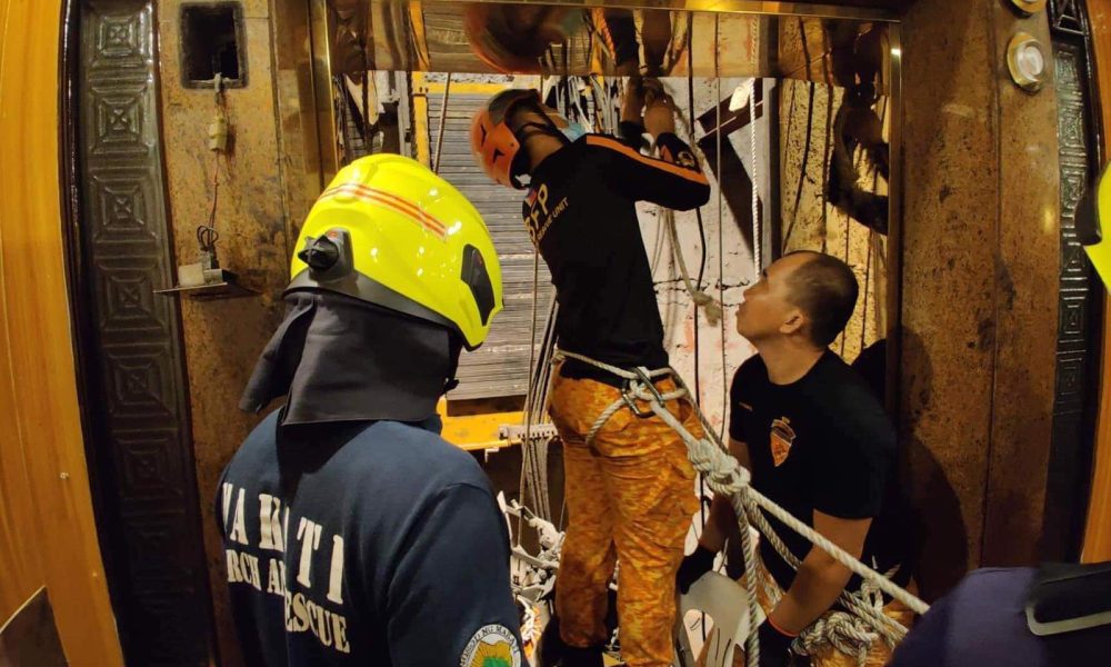 men fixing elevator wires
