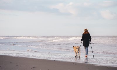 Woman walkinag with dog on the beach