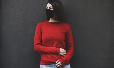 woman wearing red sweater and black mask