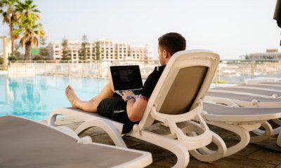 man working on laptop in front of pool