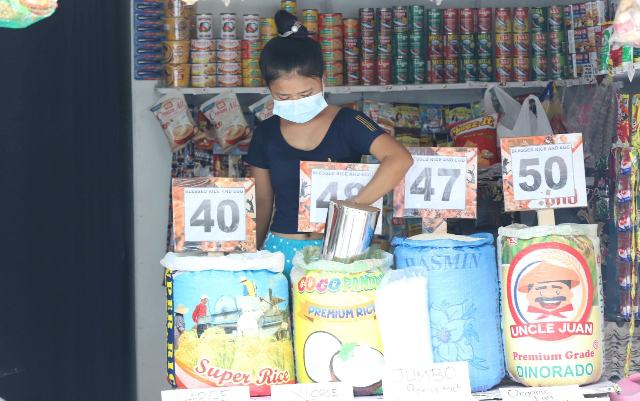 store attendant arranges one of the sacks of rice