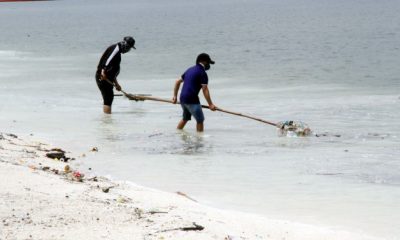 workers cleaning dolomite beach