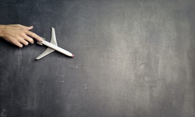 person with miniature airplane on chalkboard