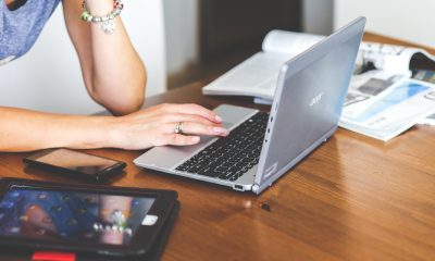 woman typing on keyboard of laptop