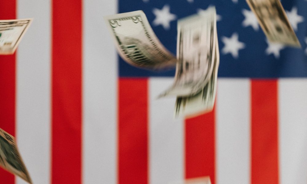 flying dollars and usa flag background