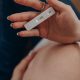 pregnant woman holding pregnancy test