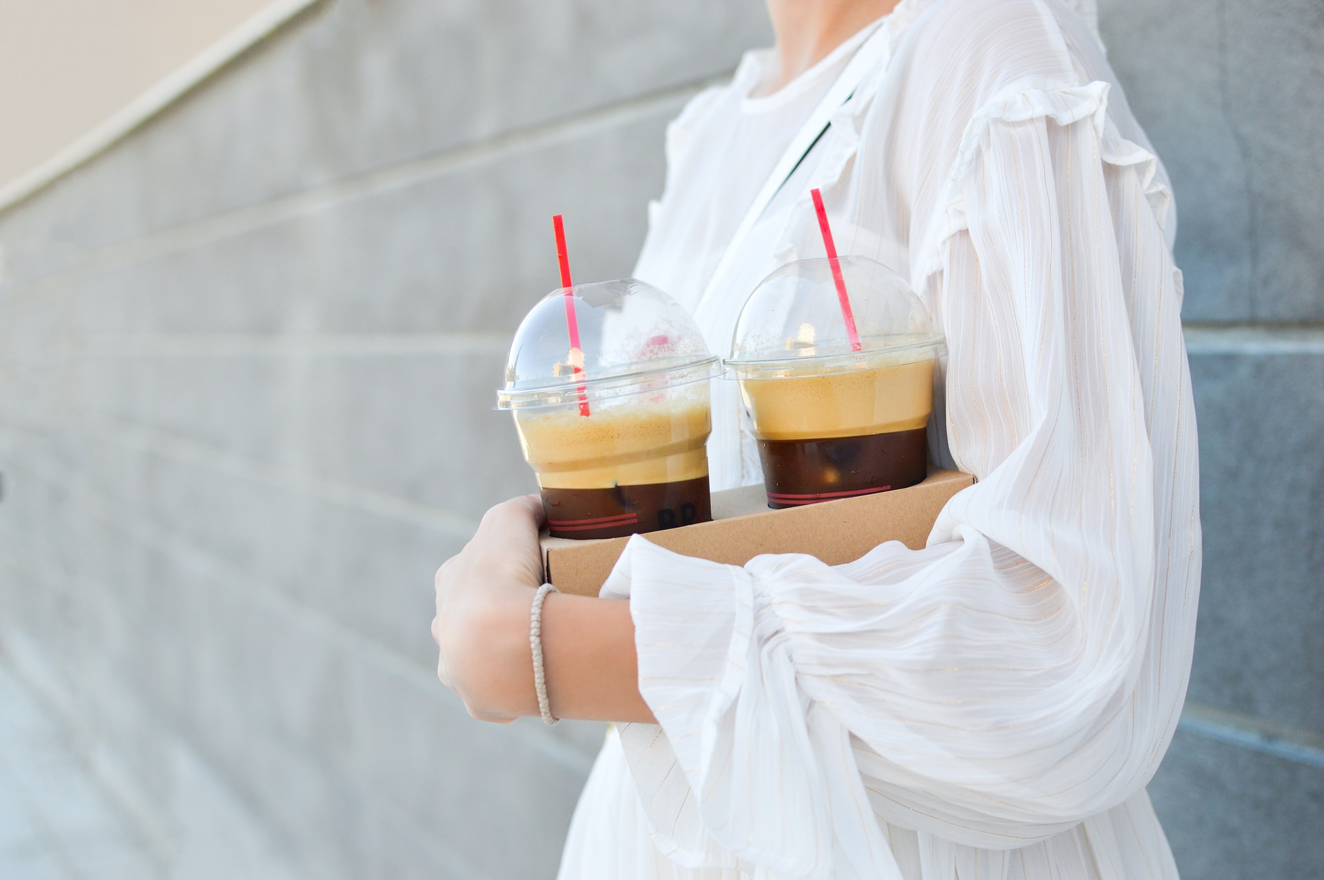 girl holding drinks with straws