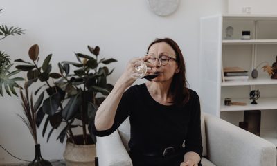 An Elderly Woman Drinking Wine while Sitting on the Chair