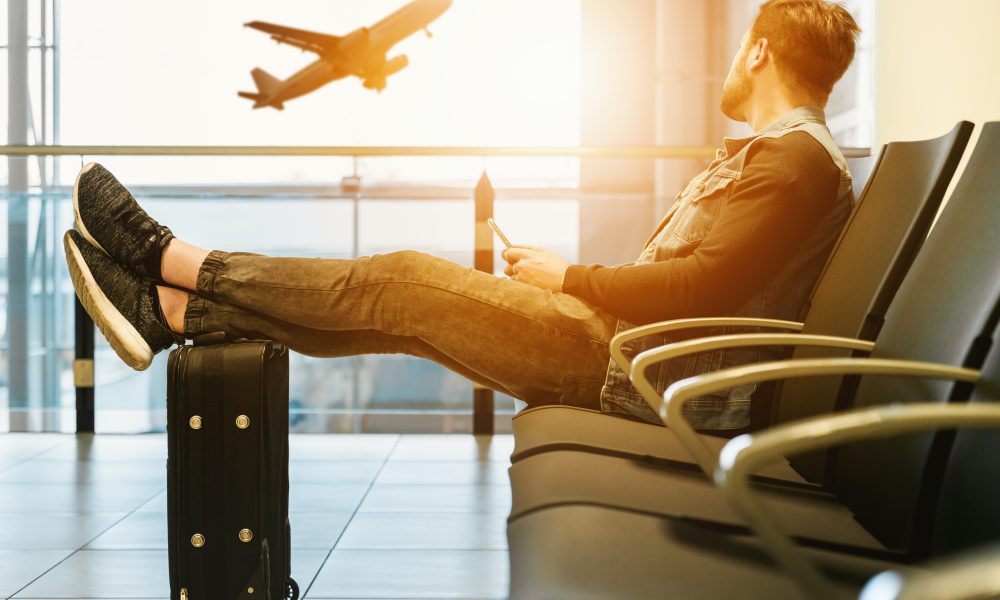 Man sitting on chair with feet on luggage