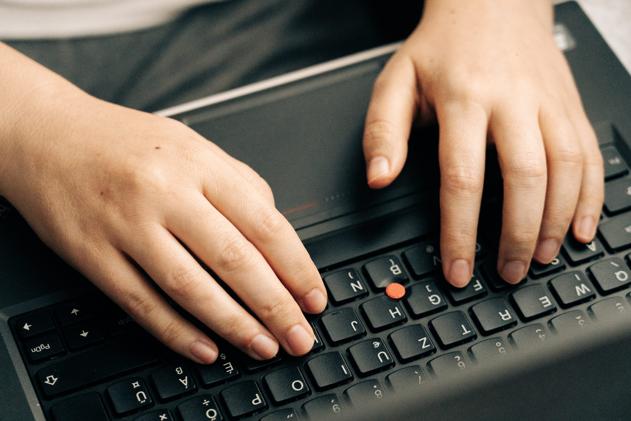 Person Typing on Black Laptop Keyboard