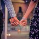 Two persons holding hands