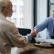 businessman shaking hand of applicant in office