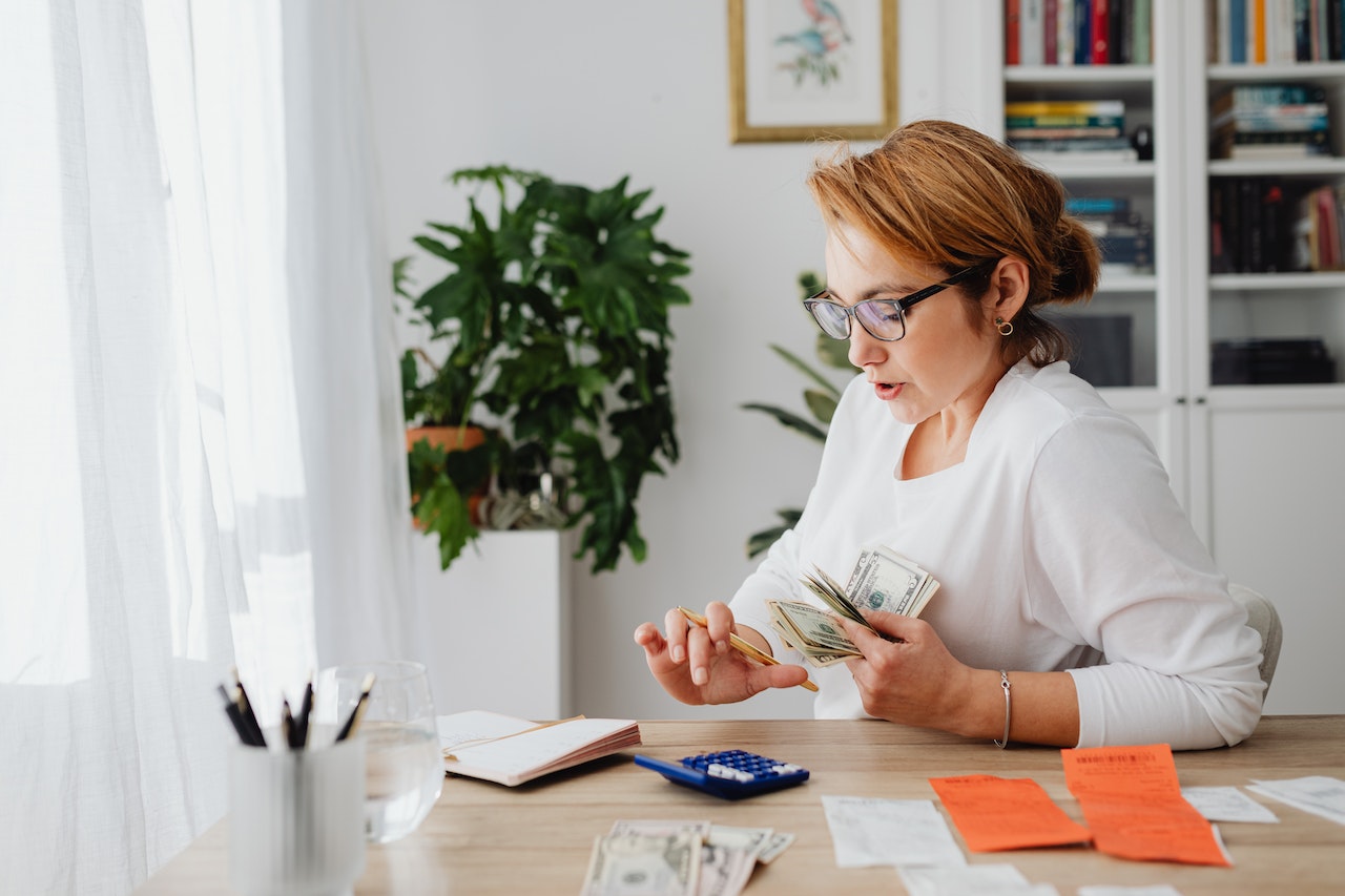 woman calculating and holding money