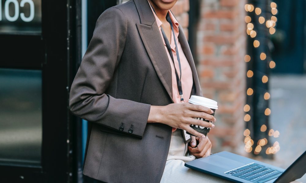 smiling businesswoman with laptop and coffee
