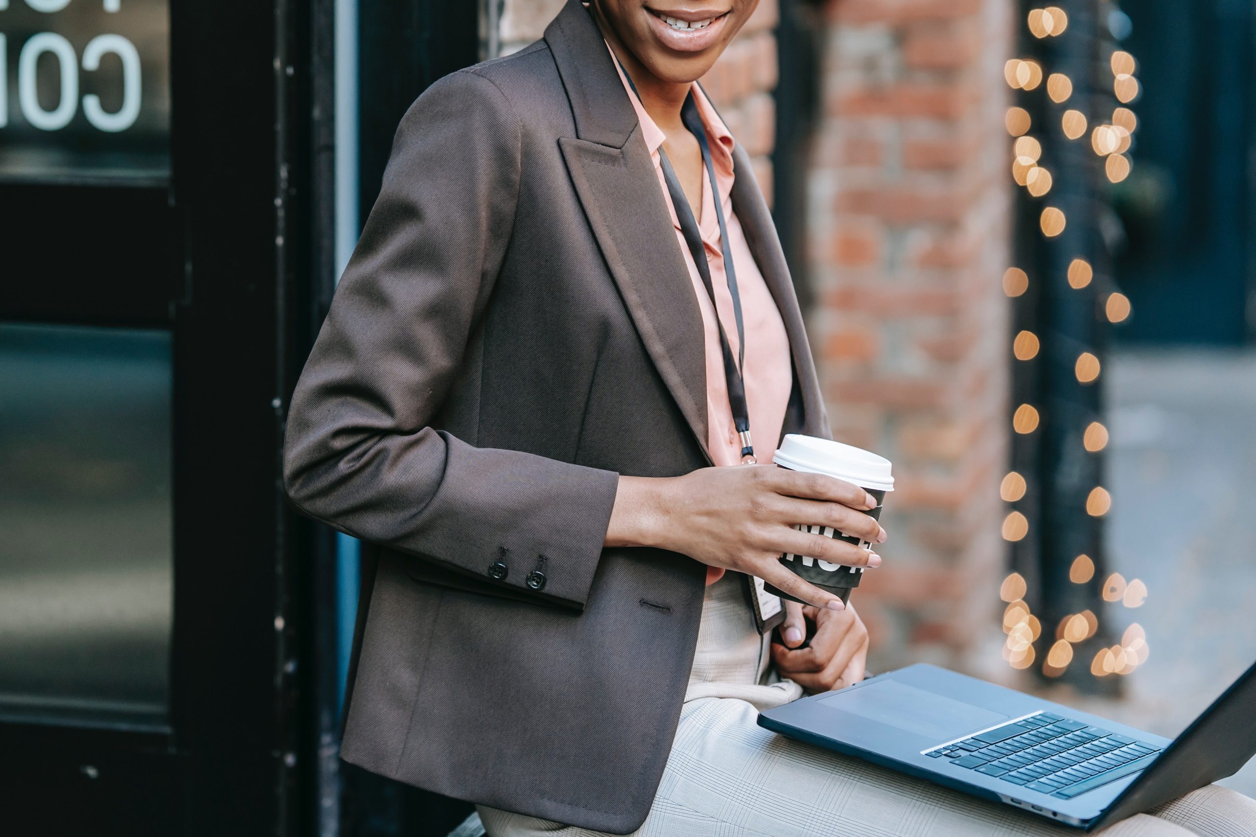 smiling businesswoman with laptop and coffee