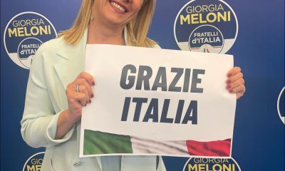Giorgia Meloni holding paperr with 'Grazie Italia'