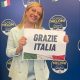 Giorgia Meloni holding paperr with 'Grazie Italia'