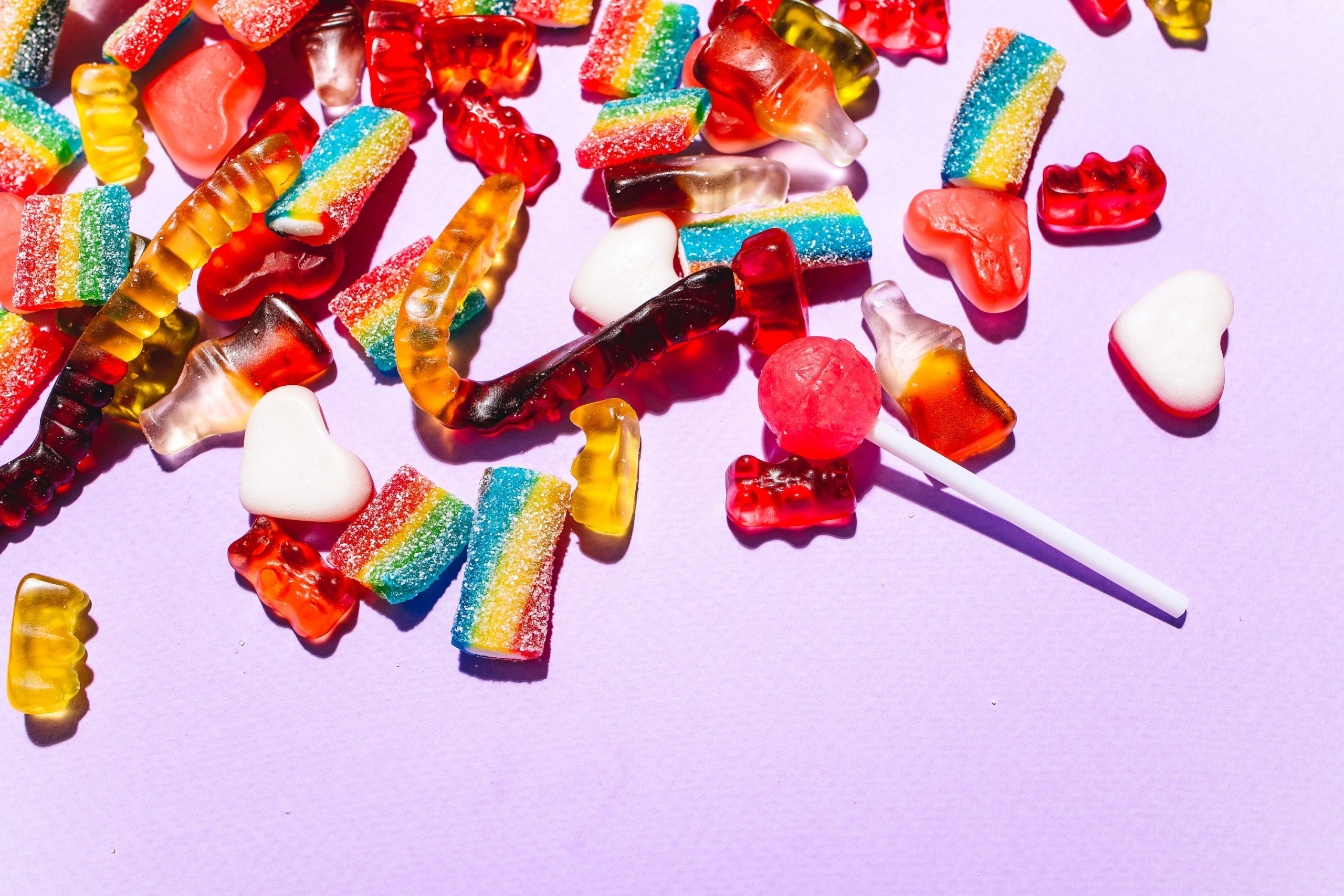 Close-Up Shot of Sweet Candies on Lilac Background