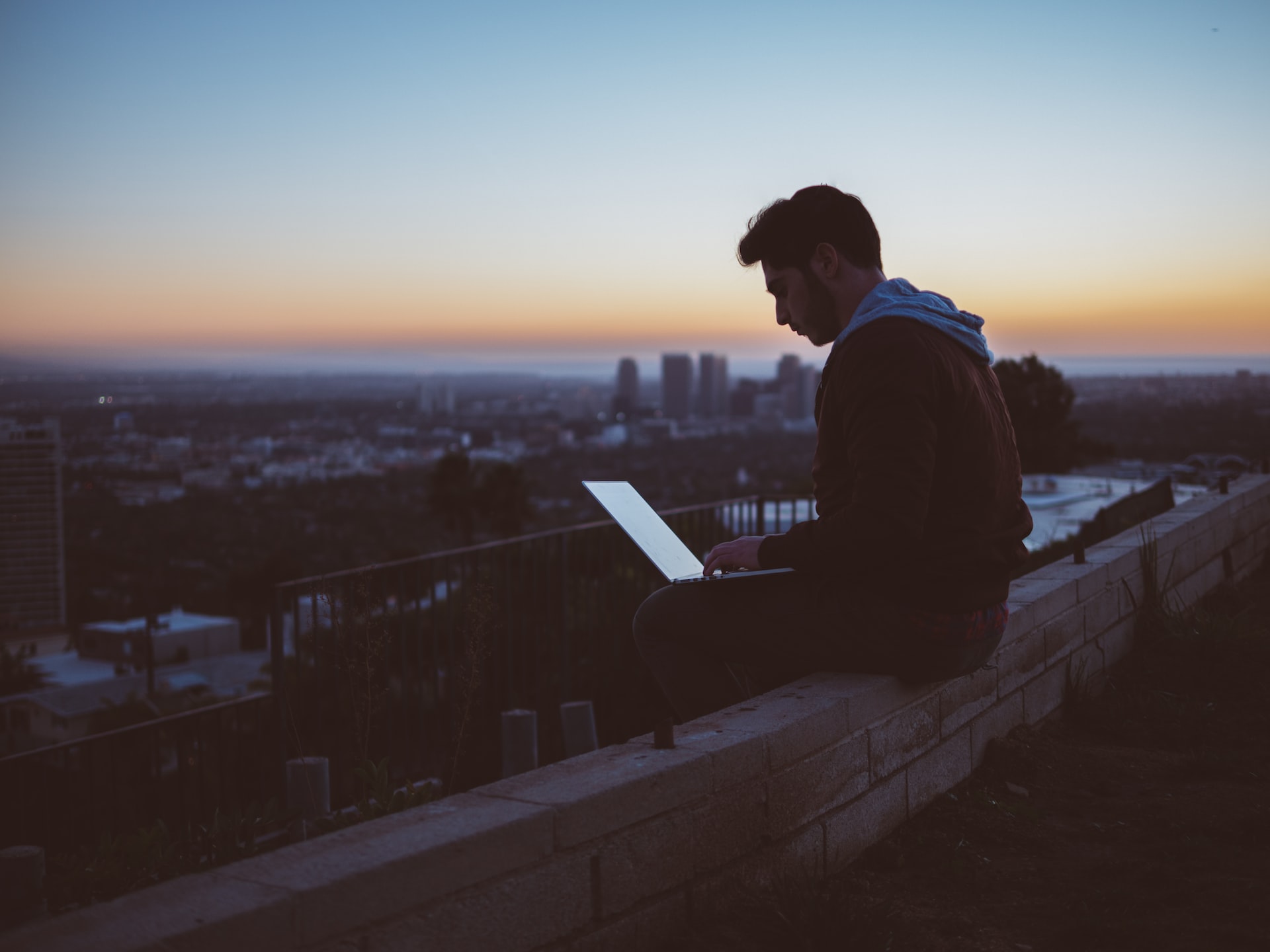 man using laptop on rooftop