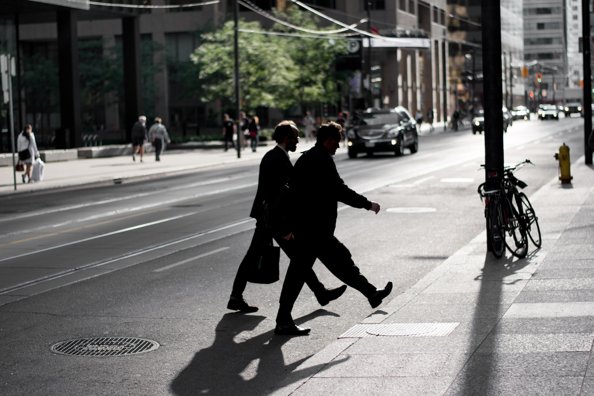 men in corporate attire crossing street