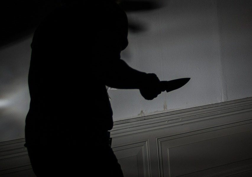 silhouette of man holding knife