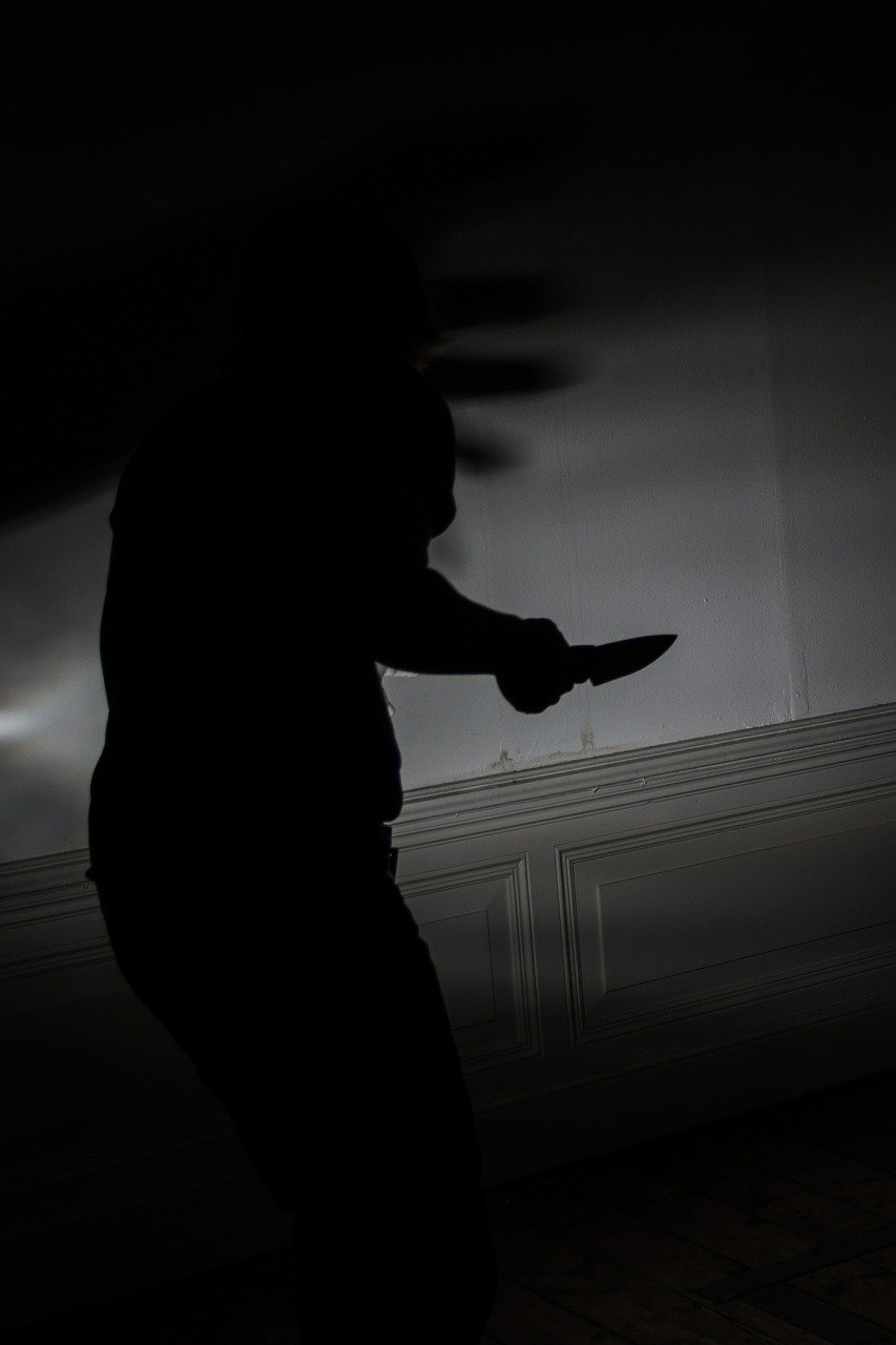 silhouette of man holding knife