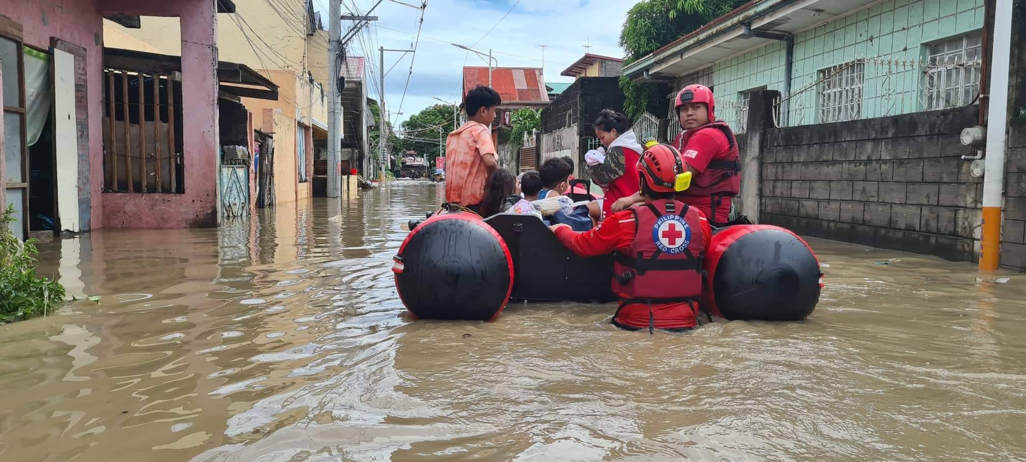 rescuers rescuing people in a float on flood