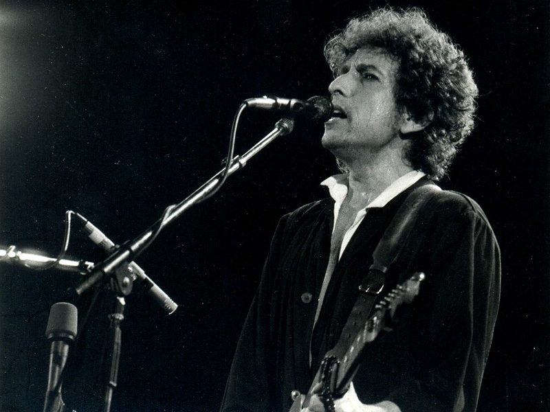 Bob Dylan playing guitar and singing