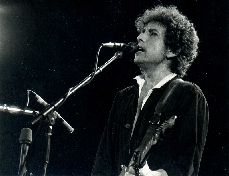 Bob Dylan playing guitar and singing