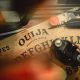 Antique ouija board with vintage camera and feathers