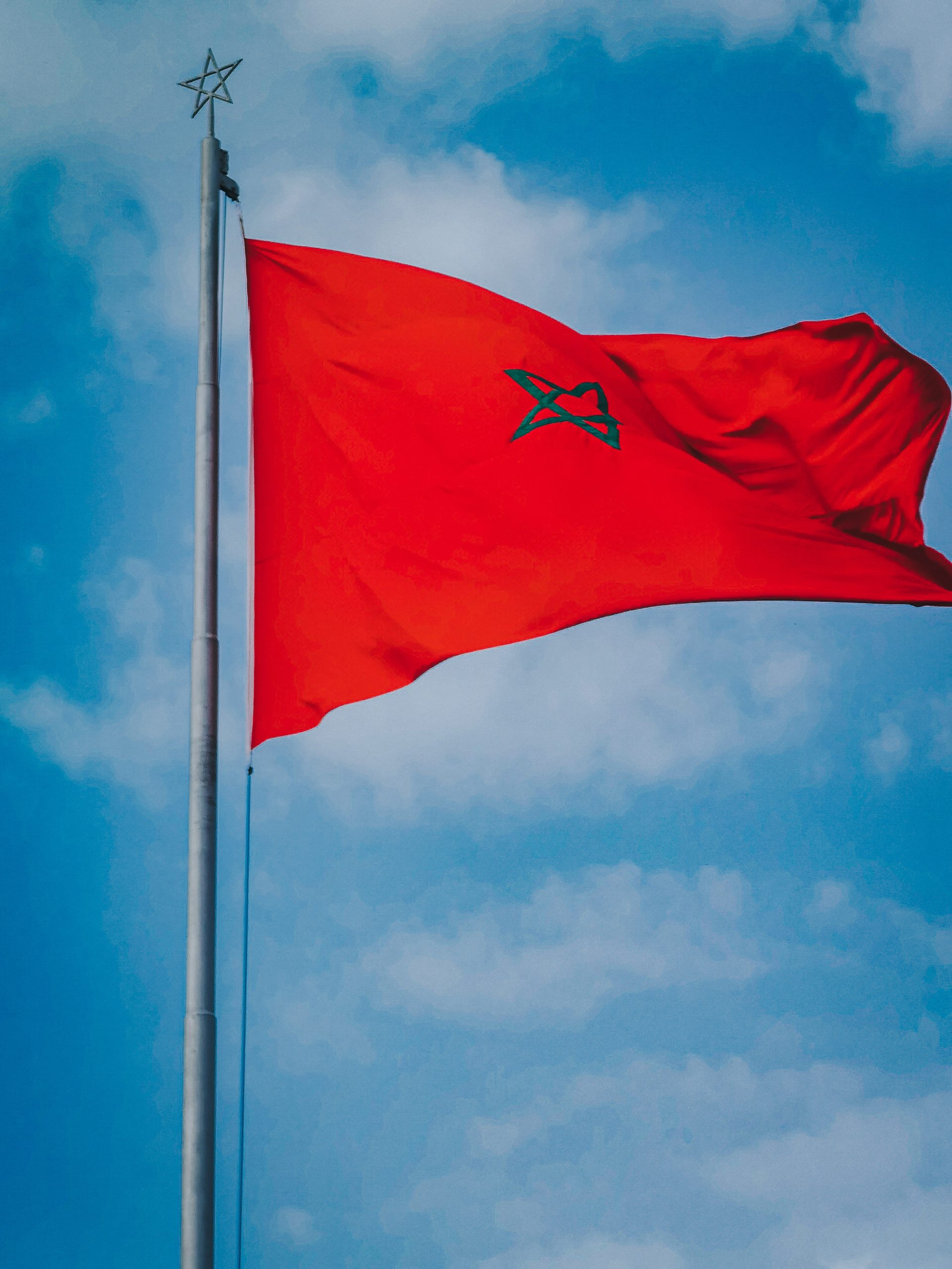 Flag of Morocco under a Cloudy Sky