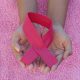Hand holding a pink ribbon